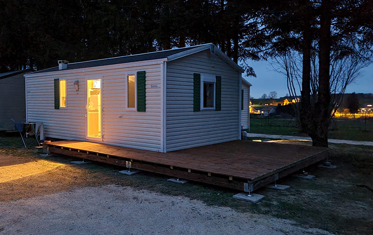 Vue extérieure de nuit du mobil-home La Vôge en location au camping les Pins à Bains-les-Bains.